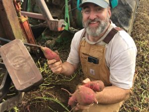 Jeremy holding sweet potatoes.